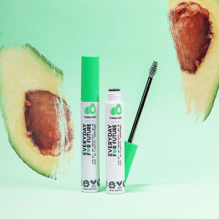 Green-capped tubes of Everyday For Future’s Clear Avocado Brow Gel with Castor Oil sit on a green backdrop. One open tube showcases its wand, enriched with organic avocado oil. Avocado illustrations at the corners emphasize its vegan and cruelty-free charm.