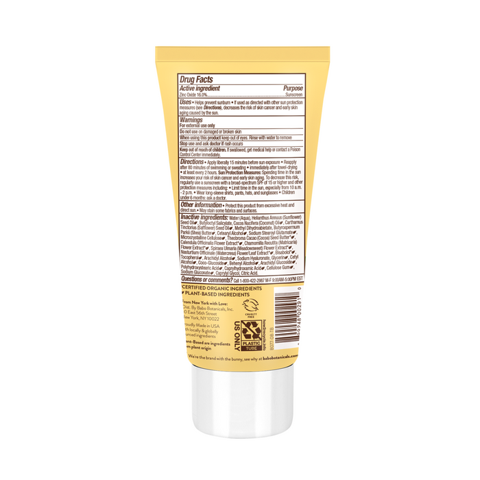 A yellow tube of Babo Botanicals Clear Zinc Sunscreen Lotion SPF 30 stands upright, featuring detailed product information and directions on the back label. It has a white cap at the bottom, recycling symbols, and is suitable for sensitive skin with broad spectrum protection.