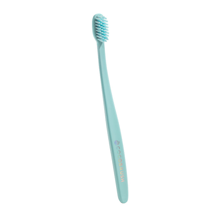 The Cocobrush Toothbrush by Cocofloss features a turquoise color, multi-density bristles, and a slim handle designed to promote healthy gums, displayed against a white background.
