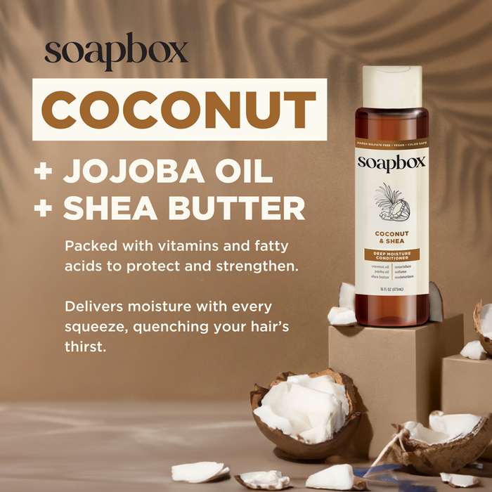 A promotional display of Soapboxs Coconut & Shea Deep Moisture Conditioner, highlighting its moisturizing benefits, is set among cracked coconut shells on a textured surface.