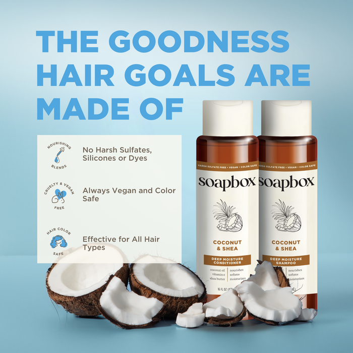 Two bottles of Soapbox Coconut & Shea Deep Moisture Shampoo, enriched with coconut oil and a vitamin complex, are surrounded by cracked coconuts. Text reads: The goodness hair goals are made of. Features include no harsh additives, vegan, color-safe, and suitable for all hair types.