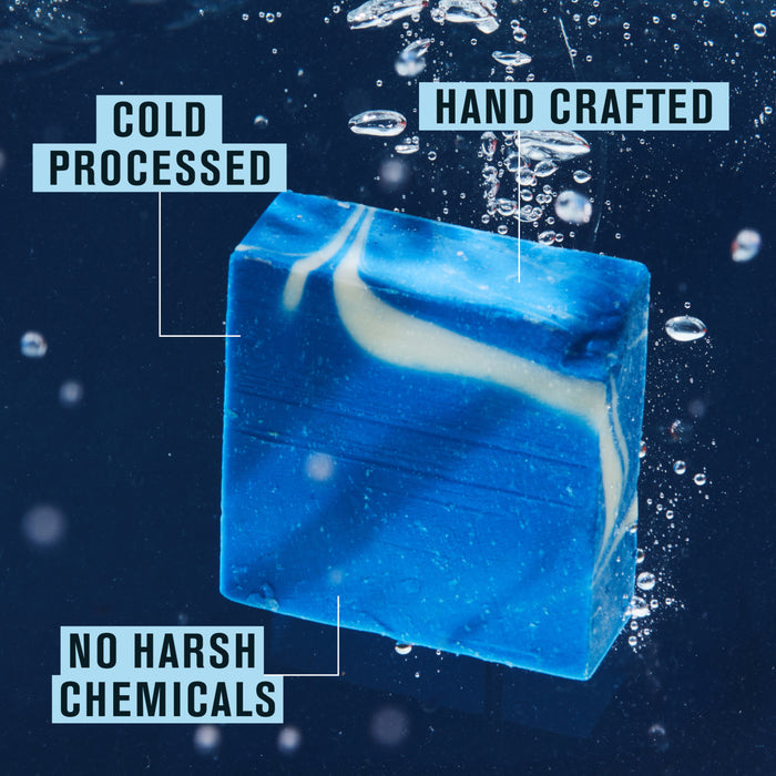 A blue and white swirled Cold Plunge Bar Soap by Every Man Jack shimmers underwater with bubbles, displaying labels: “COLD PROCESSED,” “HAND CRAFTED,” and “NO HARSH CHEMICALS.”.