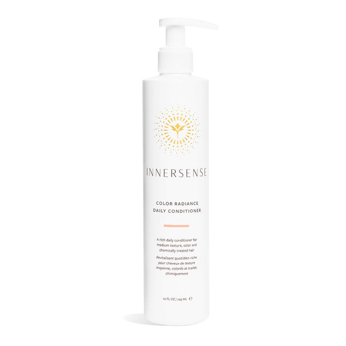 Innersense Organic Beautys Color Radiance Daily Conditioner is designed for medium textured and color-treated hair. It comes in a white bottle with a pump dispenser and features a gold abstract label, offering precise care and nourishment.