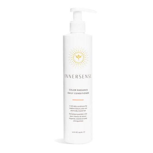 Innersense Organic Beautys Color Radiance Daily Conditioner is designed for medium textured and color-treated hair. It comes in a white bottle with a pump dispenser and features a gold abstract label, offering precise care and nourishment.