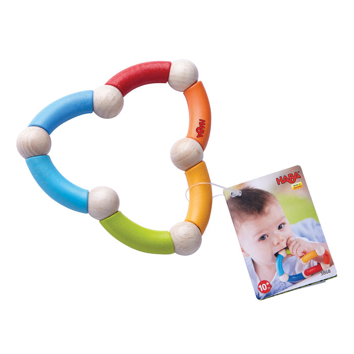 HABAs eco-friendly Color Snake Wooden Rattle & Fidget Toy features vibrant red, blue, yellow, and green segments connected by wooden balls. A tag shows a baby chewing on a similar toy. Suitable for ages 10 months and up, it helps develop gross motor skills.