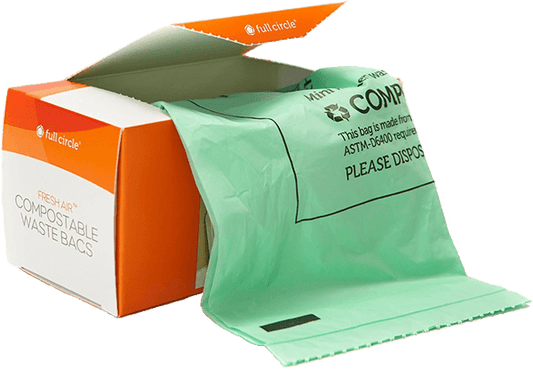 An open box of Full Circle Compostable Food Scrap Bags shows a green bag partially pulled out, with the orange and white packaging indicating theyre ASTM D6400-certified and fresh air compostable.