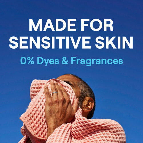 A person wipes their face with a pink cloth against a blue sky. Text above reads, Made for sensitive skin, 0% dyes & fragrances, just like Seventh Generations fragrance-free Concentrated Laundry Detergent.