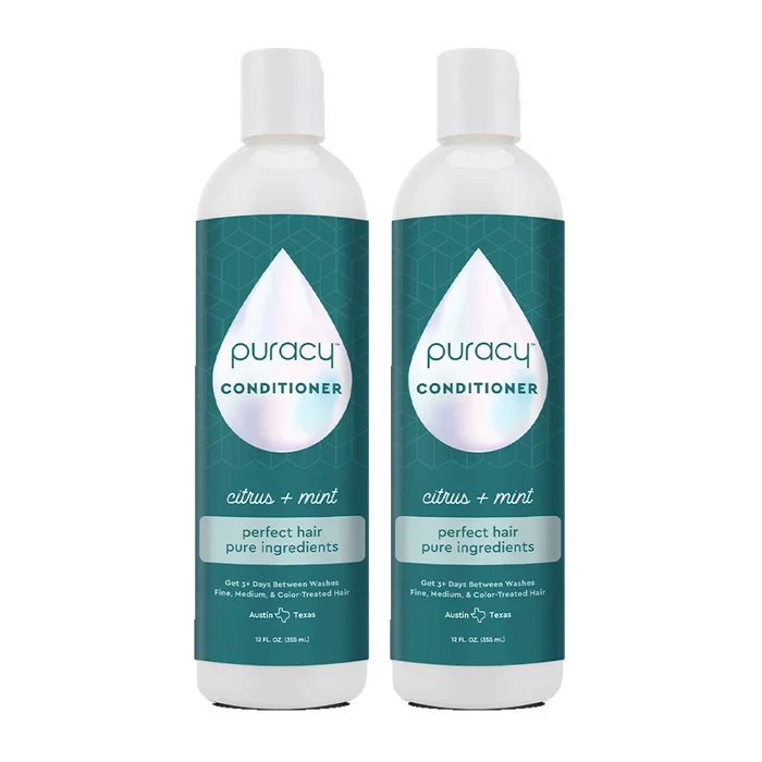 Two bottles of the Puracy Conditioner (Silicone/Dimethicone/Sulfate Free), infused with natural essential oils for deep hydration, are adorned with a teal label and white cap. This formula, free from sulfates, gently nourishes your hair.