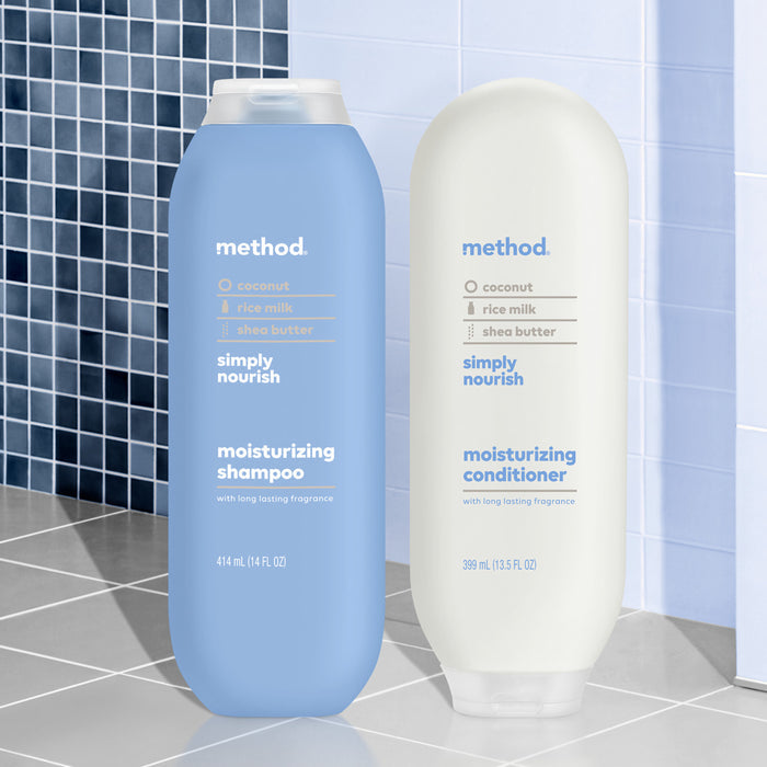 Two method hair care bottles sit elegantly in a tiled bathroom: the blue contains moisturizing shampoo, and the cream holds nourishing conditioner. Both feature coconut, rice milk, shea butter and are in cruelty-free packaging made from recycled plastic.
