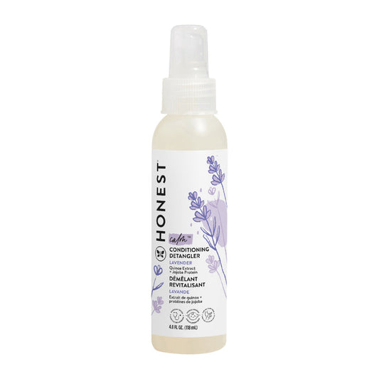 A spray bottle of The Honest Companys Conditioning Detangler features a calming lavender scent, adorned with lavender illustrations and a clear cap. The front label displays product details in black text on a white background, promising silky-smooth strands.