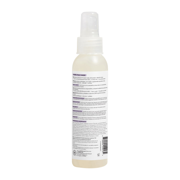 A white plastic spray bottle with a translucent cap, seen from the back, is labeled in black and purple with details about The Honest Companys Conditioning Detanglers unique formula for silky-smooth hair. A barcode adorns the bottom for easy scanning.