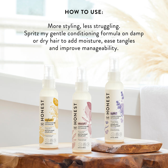 Three bottles of The Honest Companys Conditioning Detangler, each with a unique botanical design for silky-smooth strands, are on a wooden surface. A white bathtub is in the background, and usage instructions for this hair detangler appear at the top.