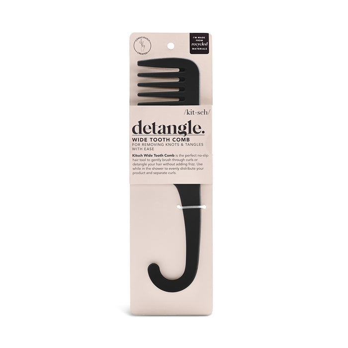 A black Kitsch Consciously Created Wide Tooth Comb with a hook handle rests in beige packaging. Labeled detangle, its perfect for removing knots effortlessly, and its no-slip texture ensures easy handling.