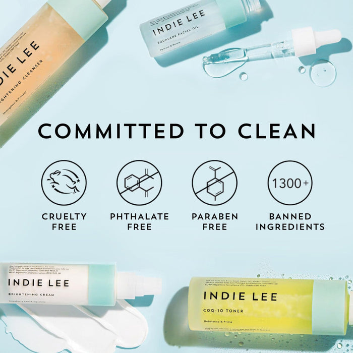 Flat lay of Indie Lee CoQ10 Toner - Travel on a light blue background, with Committed to Clean text and icons for cruelty-free, phthalate-free, paraben-free, and 1300+ banned ingredients.