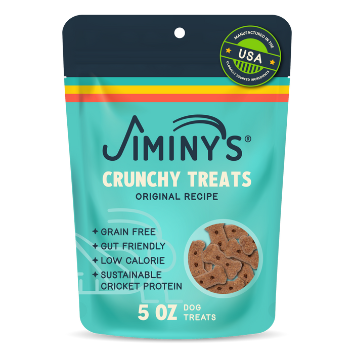 A blue, yellow, red, and turquoise pouch labeled Jiminy’s Crunchy Original Cricket Dog Treat features bone-shaped, grain-free treats for dogs made with gut-friendly, low-calorie ingredients and sustainable cricket protein.