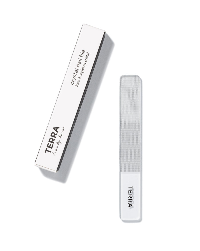 The Crystal Nail File by Terra Beauty Bars, with nano glass tech, comes in a white rectangular package labeled TERRA beauty bars. This recyclable nail file guarantees a lifetime of smooth edges and features a clear design with a frosted tip.