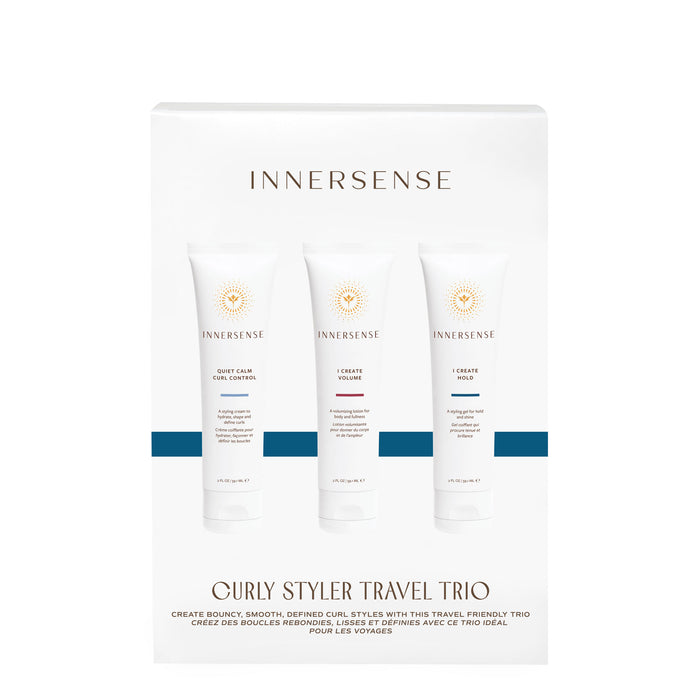 A white box labeled Curly Stylers Travel Trio by Innersense Organic Beauty contains three white tubes featuring the brands logo and names for products that provide curl control, volume, hydration, and nourishing styling cream.