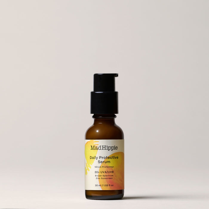 The Mad Hippie Daily Protective Serum comes in a brown bottle with a black pump. Infused with buriti oil, it offers mineral SPF 30+ UVA/UVB protection and is shown against a neutral backdrop.