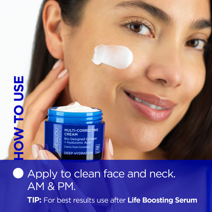 A woman smiles and applies a dab of cream to her cheek. She holds a blue jar labeled "Multi-Correcting Cream" by Andalou. The text reads, "Apply to clean face and neck. AM &amp; PM. TIP: For best results use after Life Boosting Serum.