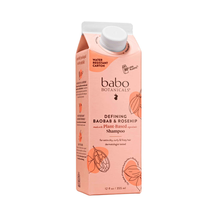 A carton of Babo Botanicals Defining Baobab & Rosehip Shampoo features nourishing baobab oil and rosehip, an orange and white design with a water-resistant finish, making it perfect for a sustainable routine with its white cap.