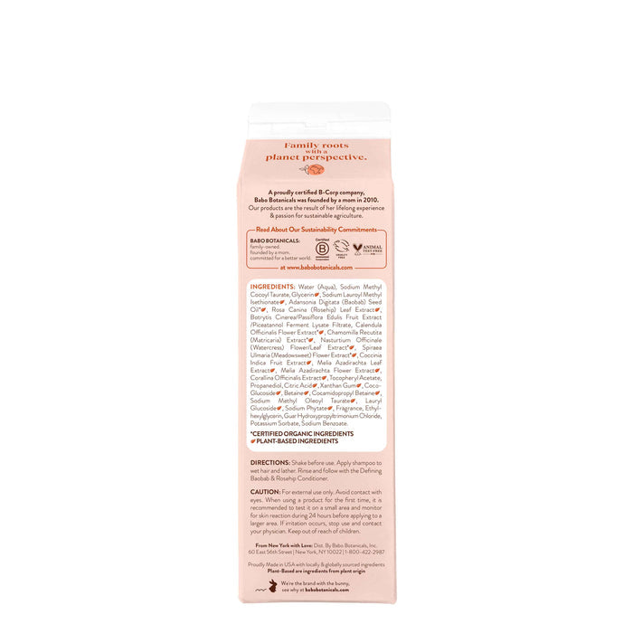 The side of the Defining Baobab & Rosehip Shampoo carton is beige and white, featuring brand details, ingredients, and directions. A red Babo Botanicals logo stands out, highlighting family roots and sustainability. Its a perfect addition to your routine with nourishing baobab oil for all hair types.