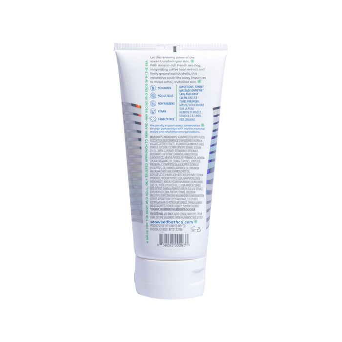 The Seaweed Bath Cos Detox Exfoliating Body Scrub in a white tube with blue and green text features benefits like being sulfate-free, cruelty-free, vegan, and gluten-free. Enhanced with French clay for detox properties, the ingredient list and website URL are visible on the back.