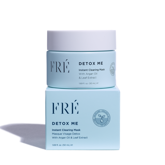 A light blue cosmetic jar labeled DETOX ME Instant Clearing Mask by FRÉ Skincare is elegantly stacked on a matching box. Infused with argan oil, leaf extract, and natural kaolin clay, this detox mask features a minimalist design with crisp typography to enhance your skincare routine.