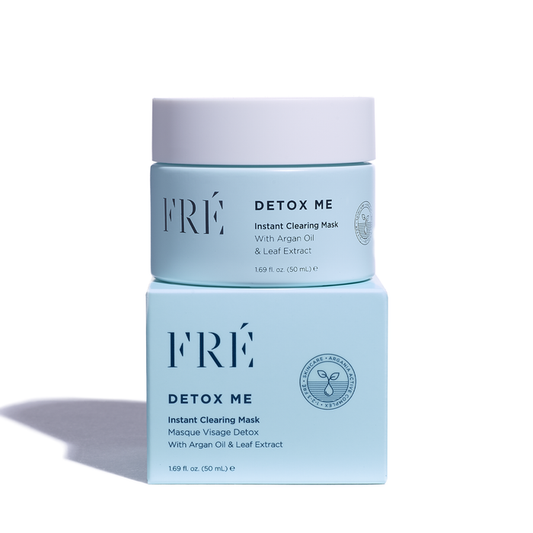 A light blue cosmetic jar labeled DETOX ME Instant Clearing Mask by FRÉ Skincare is elegantly stacked on a matching box. Infused with argan oil, leaf extract, and natural kaolin clay, this detox mask features a minimalist design with crisp typography to enhance your skincare routine.