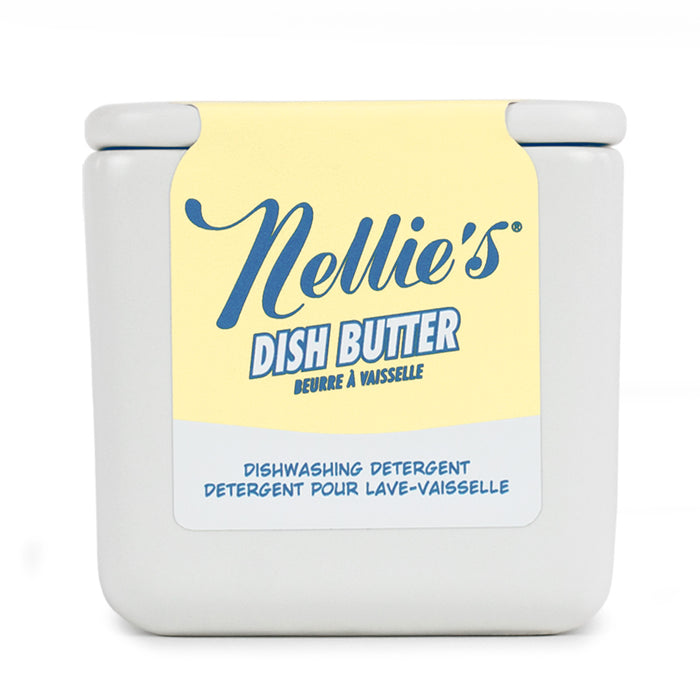 A square, white tub with a yellow and blue label reads "Nellie's Dish Butter" in English and French. This closed-lid container offers a zero-waste, convenient green cleaning solution for dishwashing.