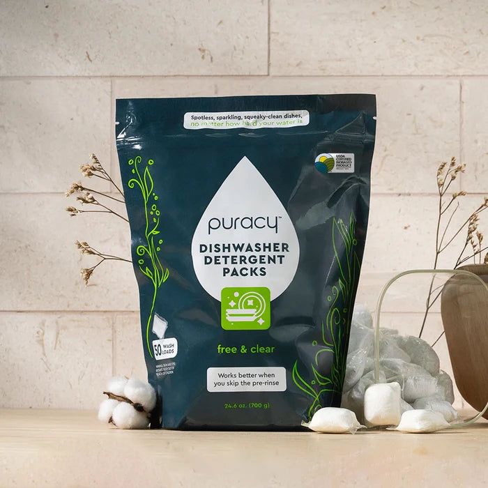 A bag of Dishwasher Detergent Pods sits on a counter with cotton and dried flowers beside it.