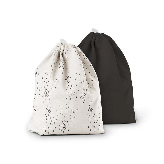 The Ditty Bag Duo Wet Bags by Esembly Baby are shown: one with a small black dot pattern and the other in plain black, both crafted from recycled plastic and neatly gathered at the top, ideal for storing cloth diapers or essentials.