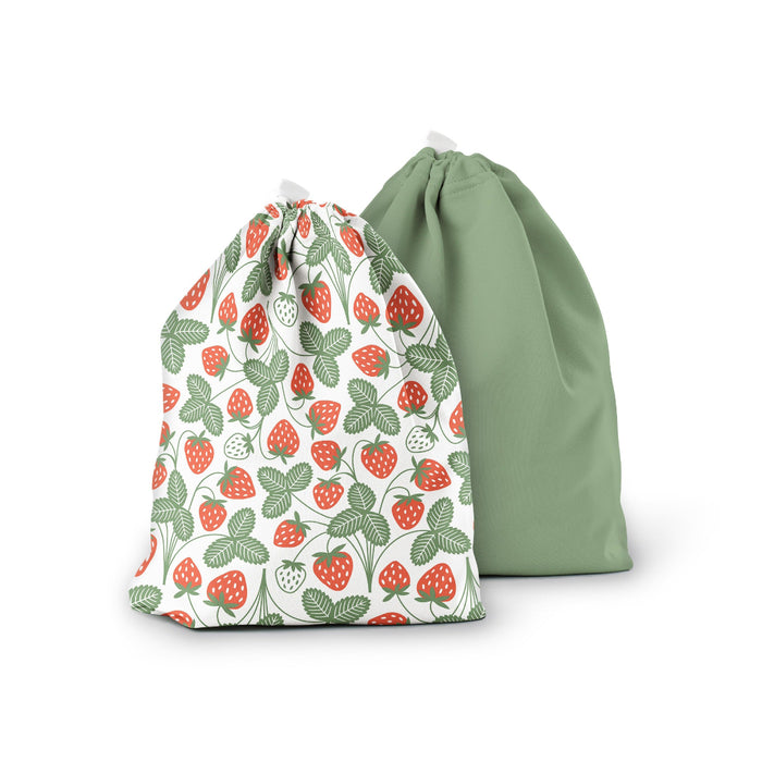The Ditty Bag Duo Wet Bags by Esembly Baby display two fabric designs: one with red strawberries and green leaves on white, and the other in solid sage green. Both bags include drawstring closures and are ideal as charming wet bags for cloth diapers.