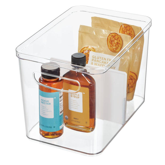 The iDesign Divided Organizer Bin with Handles, made from BPA-free recycled plastic, elegantly holds two bottles labeled Agave Nectar and Maple Syrup plus two packages of Gluten Free Pancake & Waffle Mix, all showcased on a white background.