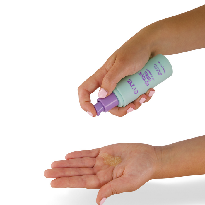 A person dispenses evre.s Do Your Thing AHA & BHA Gel Cleanser from a light green bottle with a purple pump into their hand. The brown gel-like cleanser targets blackheads and breakouts, with partially visible text on the bottle.