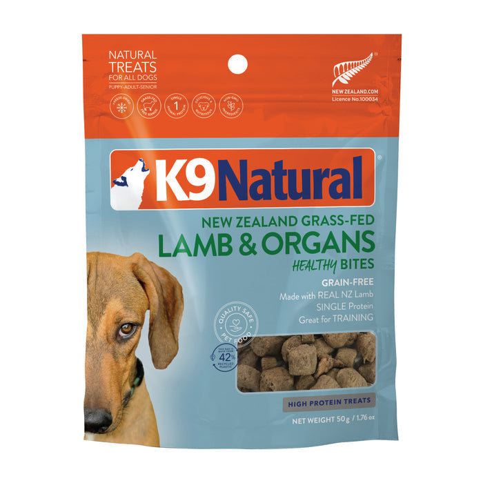 K9 Naturals Grain-Free Freeze-Dried Dog Treats feature a lamb and organs flavor in orange and blue packaging with a dog photo. Made from New Zealand grass-fed lamb, they offer high protein for your pets natural enjoyment.