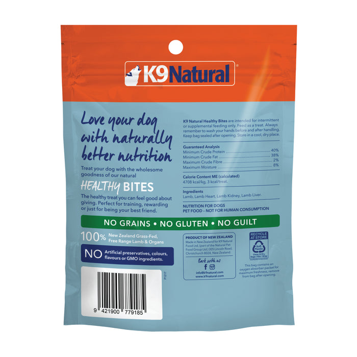 The back of an orange K9 Natural dog food bag displays nutritional info and premium ingredients like New Zealand grass-fed beef and free-range lamb organs, emphasizing No Grains, No Gluten, making it an ideal pair with Grain-Free Freeze-Dried Dog Treats for a wholesome diet.