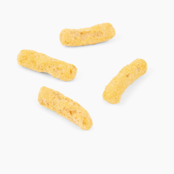 Four yellow, textured Jiminys Dog Treats lie on a white background, resembling crunchy corn sticks. Each bite offers a delightful protein boost with the savory flavor of nutritional yeast.