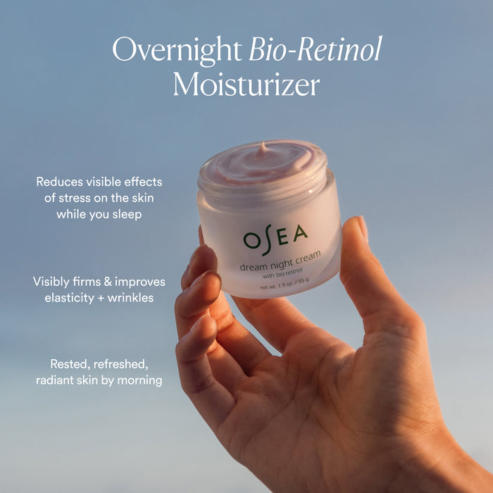 A hand holds a jar of OSEA Dream Night Cream with Bio-Retinol against a soft sky. This overnight moisturizer firms, improves elasticity, reduces visible stress effects, and leaves skin refreshed and radiant by morning.