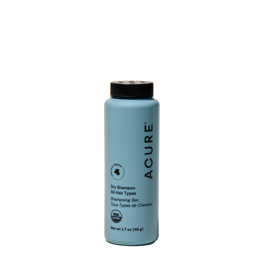 Acure Dry Shampoo, for all hair types, comes in a 1.7 oz light blue bottle with a black cap and text. This waterless formula absorbs hair oil and features both English and French labeling.