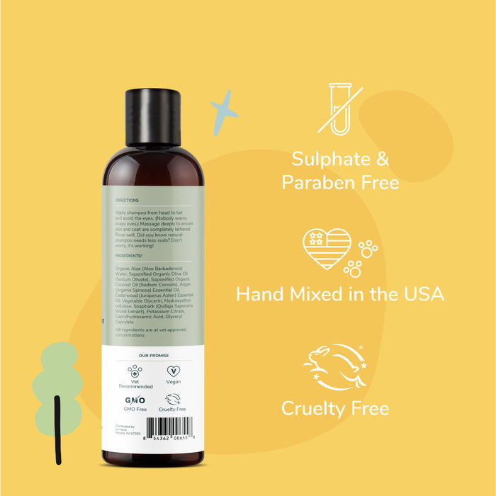 A bottle of kin+kind Dry Skin & Coat Dog Shampoo with a black cap on a yellow background. Text highlights its Sulphate & Paraben Free, Hand Mixed in the USA, and Cruelty Free features, alongside icons. Instructions and ingredients are visible for natural pet care enthusiasts.