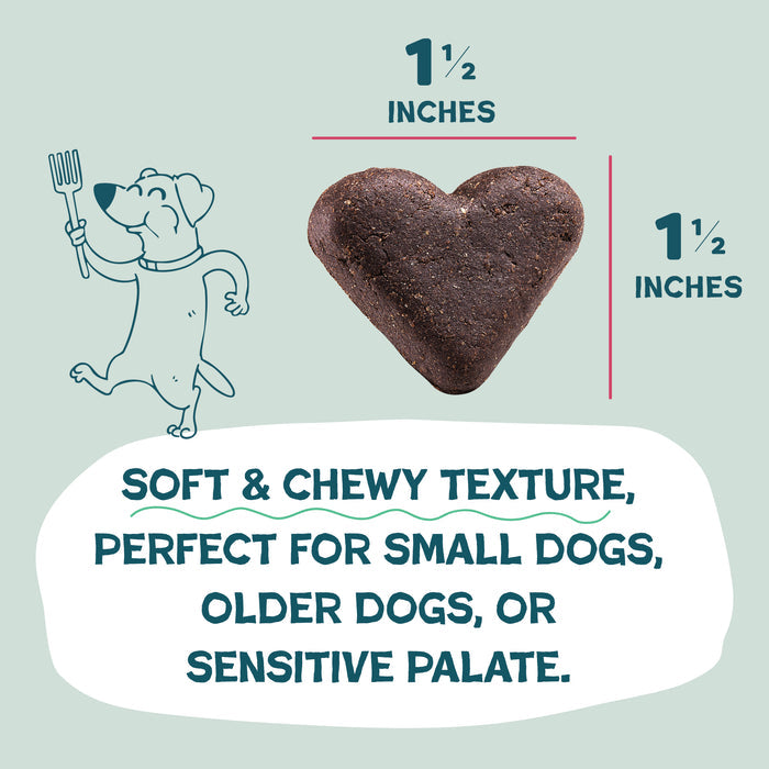 A 1.5 heart-shaped Shameless Pets Duck Duck Beet Soft-Baked Dog Treat sits by a smiling dog with a fork. Text: Soft & chewy texture—ideal natural treat for small dogs, seniors, or sensitive palates.