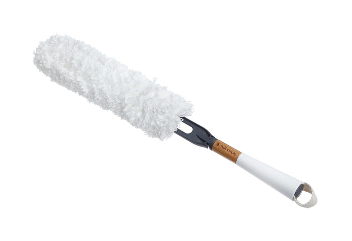 The Full Circle Dust Whisperer Filament Microfiber Duster features a fluffy white head, long handle, and hanging loop. Partially covered with a brown sleeve, this washable duster is ideal for cleaning surfaces using efficient microfiber technology.