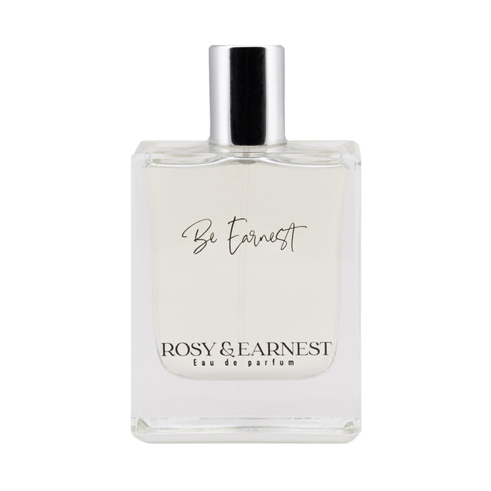 The Be Earnest perfume by Rosy & Earnest is a clear bottle capped in silver, labeled elegantly with its name. Below, its marked Eau de Parfum. This vegan scent is light and transparent with a subtle woody aroma.