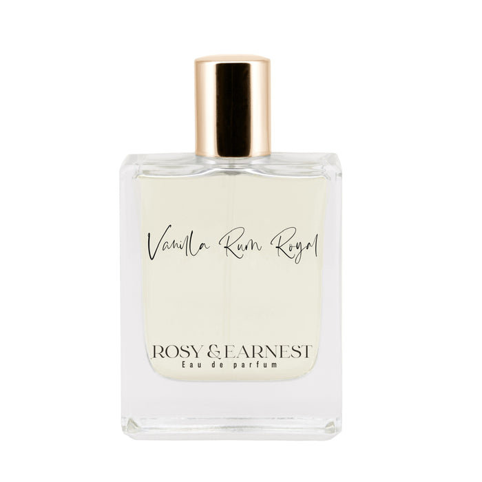 The clear perfume bottle with a gold cap is elegantly labeled as Vanilla Rum Royal by Rosy & Earnest Eau de Parfum, containing a light-colored liquid that promises a delightful gourmand fragrance experience.