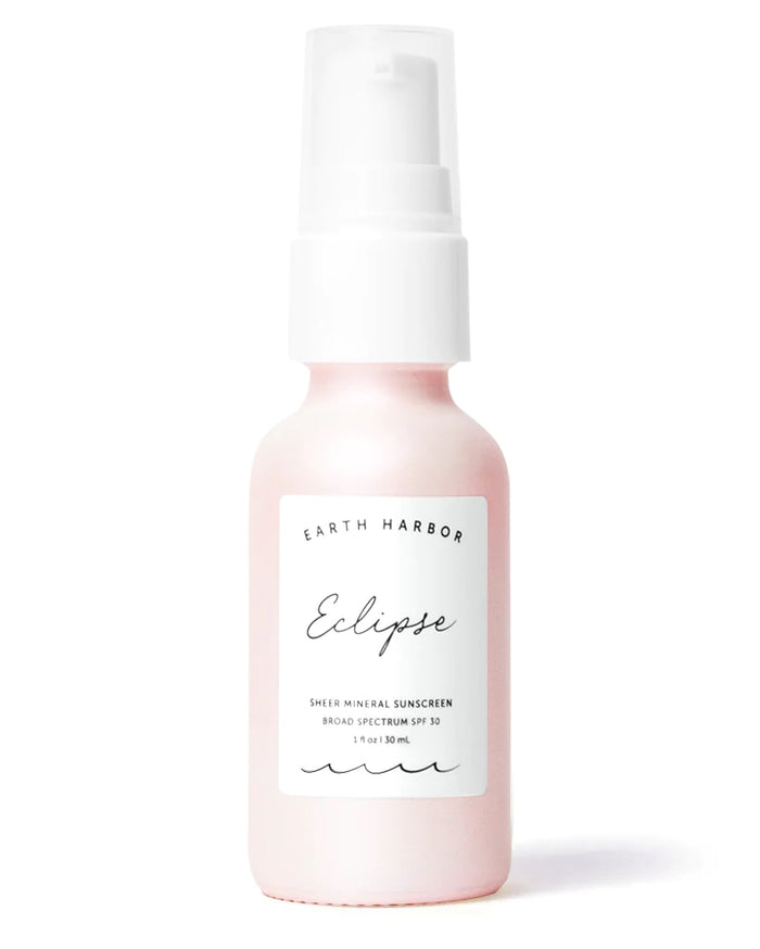A 1 fl oz (30 ml) pink and white bottle of ECLIPSE Sheer Mineral Sunscreen by Earth Harbor provides broad-spectrum SPF 30 protection, featuring elegant black text on a white label with a convenient white pump dispenser.