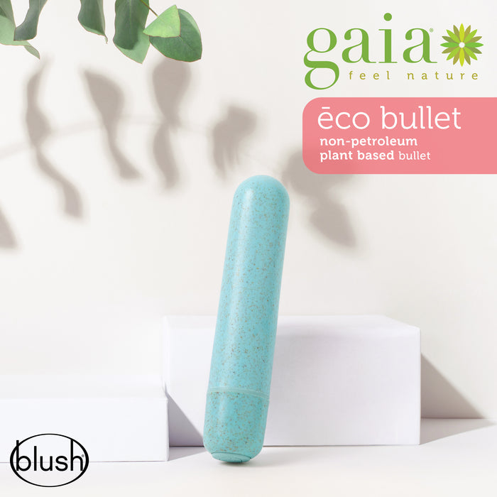 A teal-colored, plant-based cylindrical object is placed on white geometric shapes. Green leaves hang above. Branding includes "gaia feel nature" and "blush" logos, and the text "éco bullet non-petroleum plant based bullet".