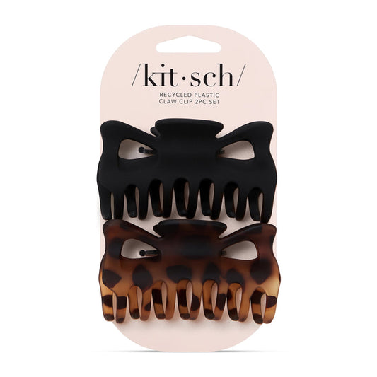 The packaging contains two Eco-Friendly Large Claw Clips by Kitsch, both made of recycled materials. The top clip is solid black, and the bottom features a tortoiseshell pattern, helping to reduce plastic waste. The brand name kit•sch is prominently displayed on the top of the packaging.