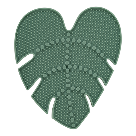The EcoTools Eco Makeup Brush Cleansing Pad, crafted from cruelty-free, dark green silicone and shaped like a monstera leaf, features a textured surface with raised bumps and lines, perfect for efficiently cleaning makeup brushes while offering both functionality and style.