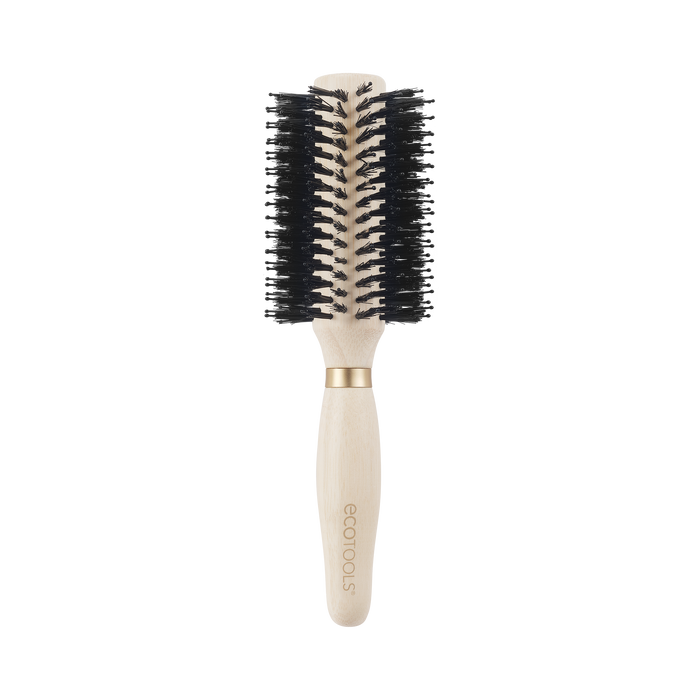 The Eco Volumizing Round Brush by EcoTools features a light wood handle crafted from 100% renewable bamboo, black vegan boar bristles, an engraved brand name on the handle, and an elegant gold ring separating the handle from the bristle area.