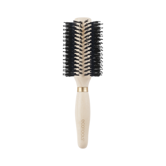 The Eco Volumizing Round Brush by EcoTools features a light wood handle crafted from 100% renewable bamboo, black vegan boar bristles, an engraved brand name on the handle, and an elegant gold ring separating the handle from the bristle area.